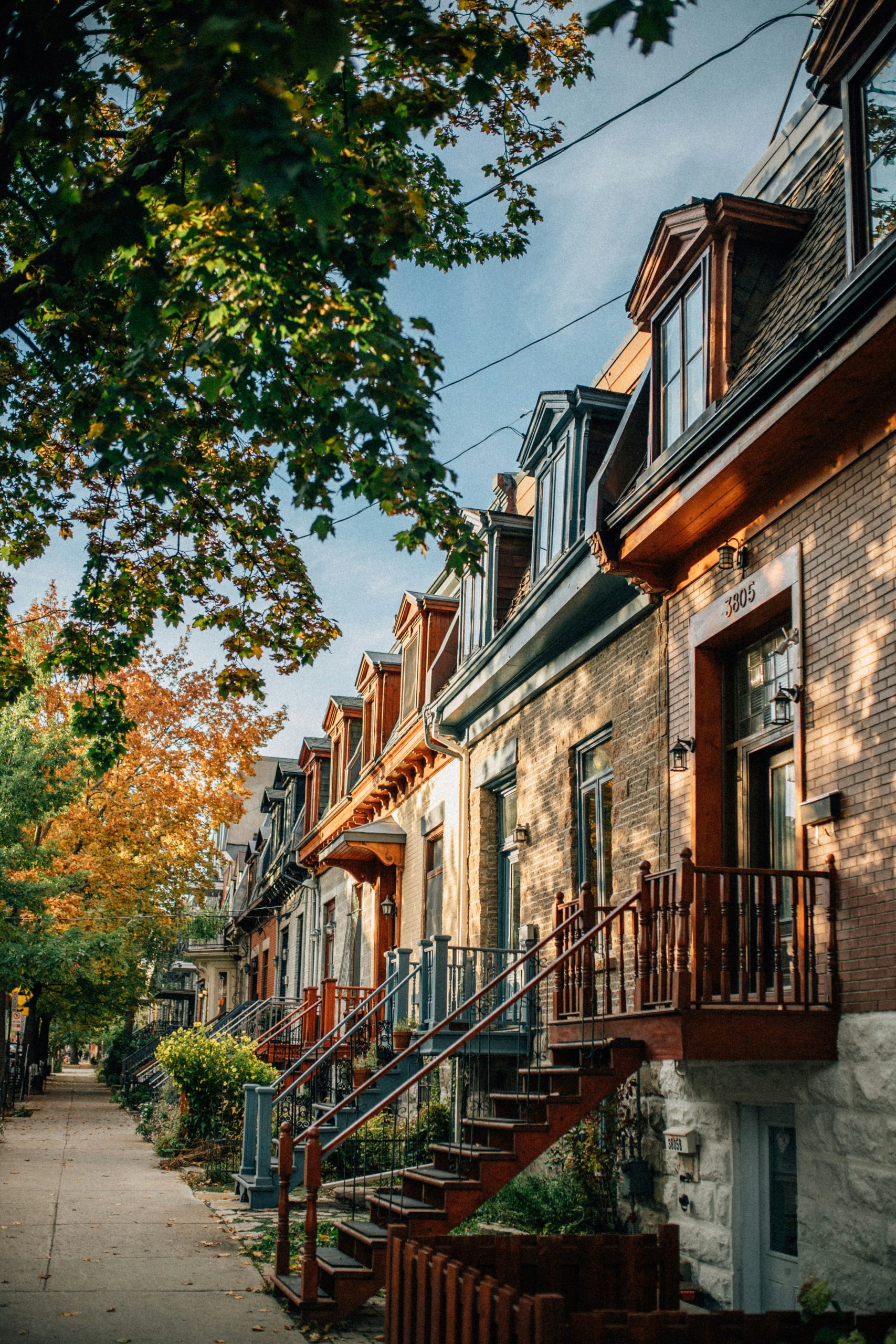 A picturesque row of houses lined along a street, adorned with vibrant fall foliage and autumn colors.