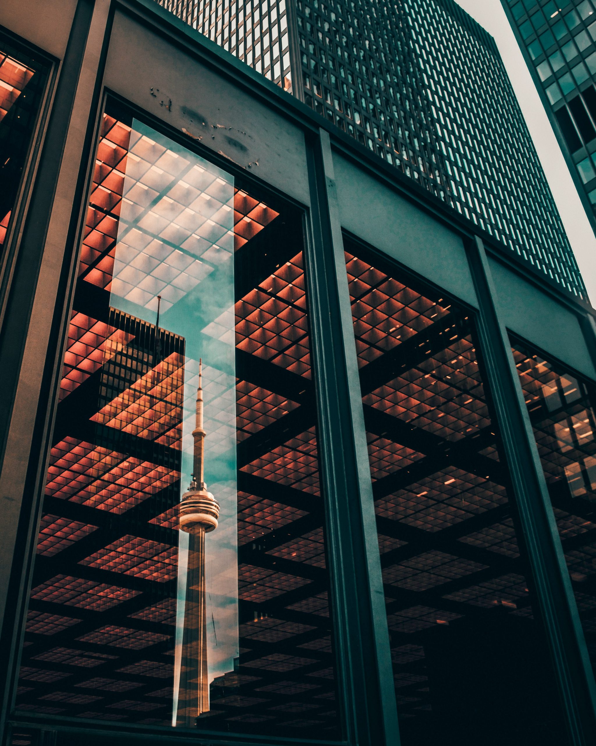 A building front window reflecting a tower in the background.